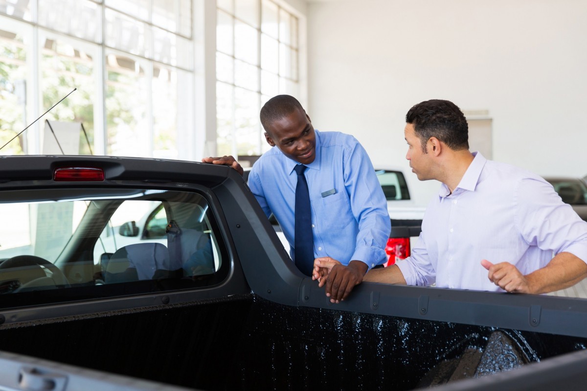 salesman talking to customer about a new vehicle